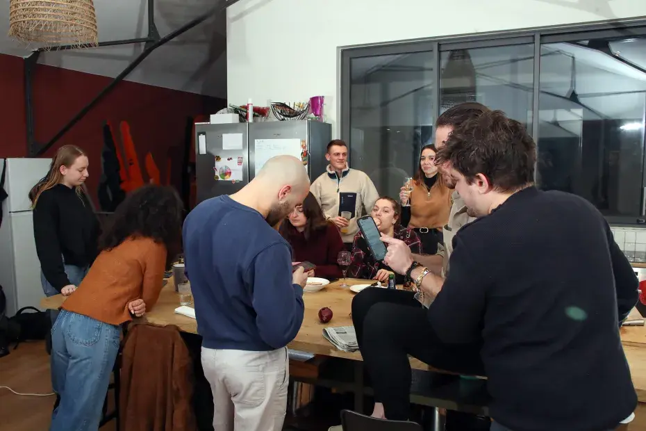 Des étudiants partagent un repas dans une vaste pièce. Il sont heureux