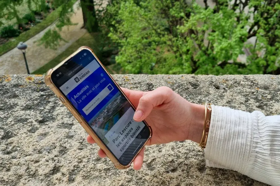 Photo d'une personne utilisant son téléphone pour faire une recherche sur le site web de la Ville de Bordeaux