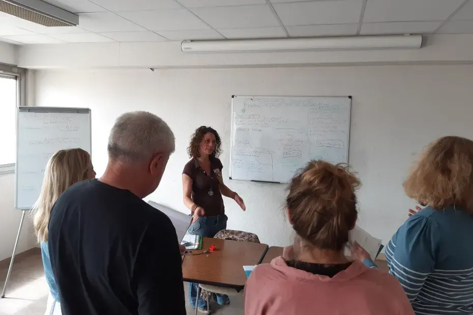Salle avec une formatrice expliquant des choses à des personnes