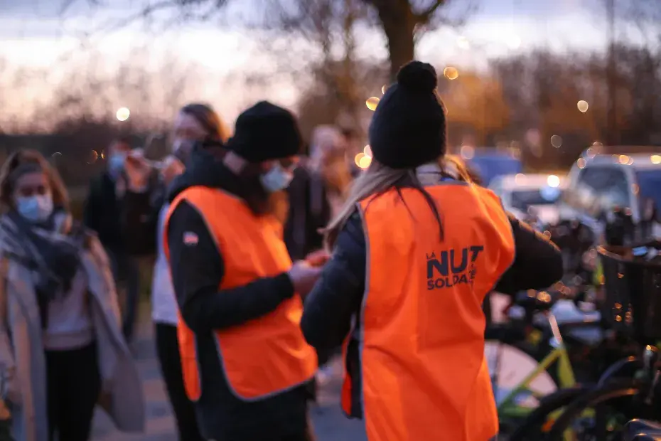 Photo de personnes avec des chasubles de la Nuit de la solidarité en début de soirée