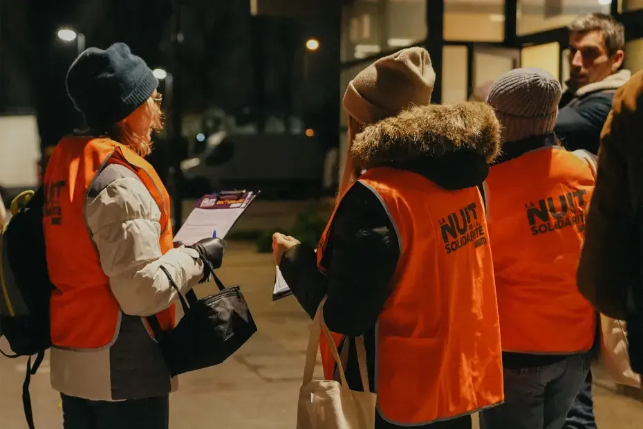 Photo de bénévoles de la Nuit de la solidarité avec des questionnaires en main