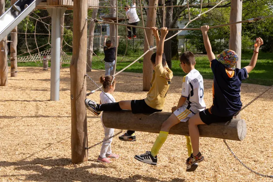 Trois enfants jouant dans un air de jeu