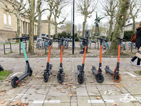 Des trottinettes garées sur un emplacement aménagées pour elles.