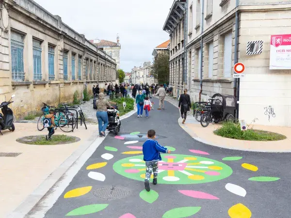Des familles marchent dans une rue de Bordeaux pour accéder à une école.