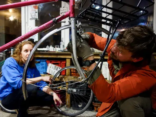 Deux personnes réparant un vélo de seconde main