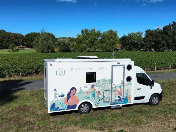 Le véhicule utilitaire de la halte-garderie itinérante stationné au bord d'une route de campagne