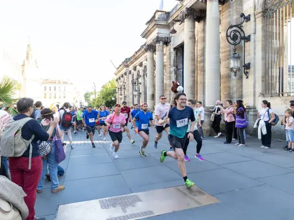Photo des coureurs et de la foule de la 3e Nuit des relais sur la place Pey Berland en juin 2024