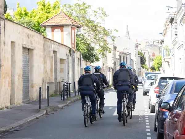 Photo de plusieurs policiers municipaux à vélo dans une rue de Bordeaux