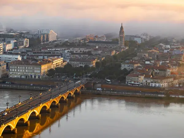 Photo en hauteur de la vue sur le pont de pierre et la place Stalingrad sur la rive droite de Bordeaux sous la brume matinale