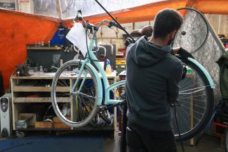 Un homme répare un vélo.