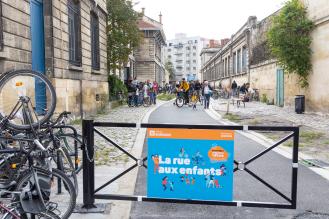 Des familles marchent dans une rue de Bordeaux pour accéder à une école.