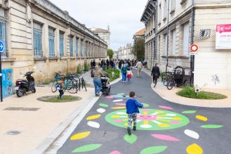 Des familles marchent dans une rue de Bordeaux pour accéder à une école.