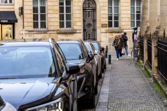 Une rue de bordeaux avec des voitures stationnées sur le bord.