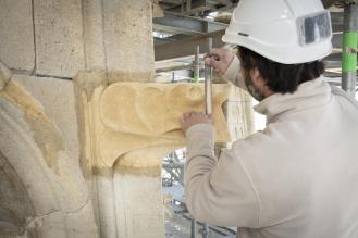 Photo d'un tailleur de pierre au travail sur le chantier de la flèche Saint-Michel.