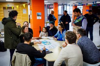 Personnes discutant autour d'une table séance de concertation sur le futur éco-quartier de la Jallère.