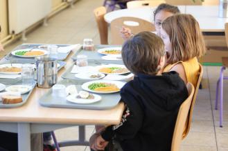 Des enfants mangent ensemble à la cantine scolaire.
