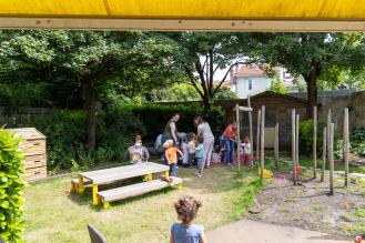 Des enfants et des femmes dans un jardin verdoyant