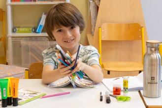 Photo d'un enfant avec le kit de fournitures soclaires