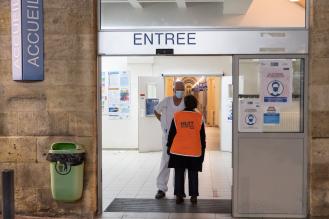 Photo d'un bénévole et d'un infirmier à l'entrée d'un hôpital