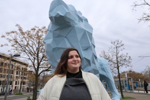 Namira debout à côté du lion de la place Stalingrad