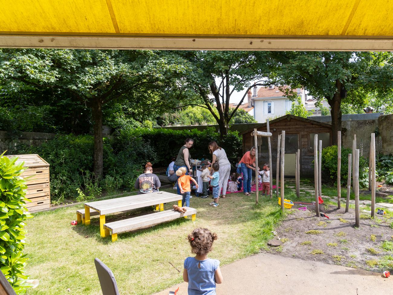 Des enfants et des femmes dans un jardin verdoyant