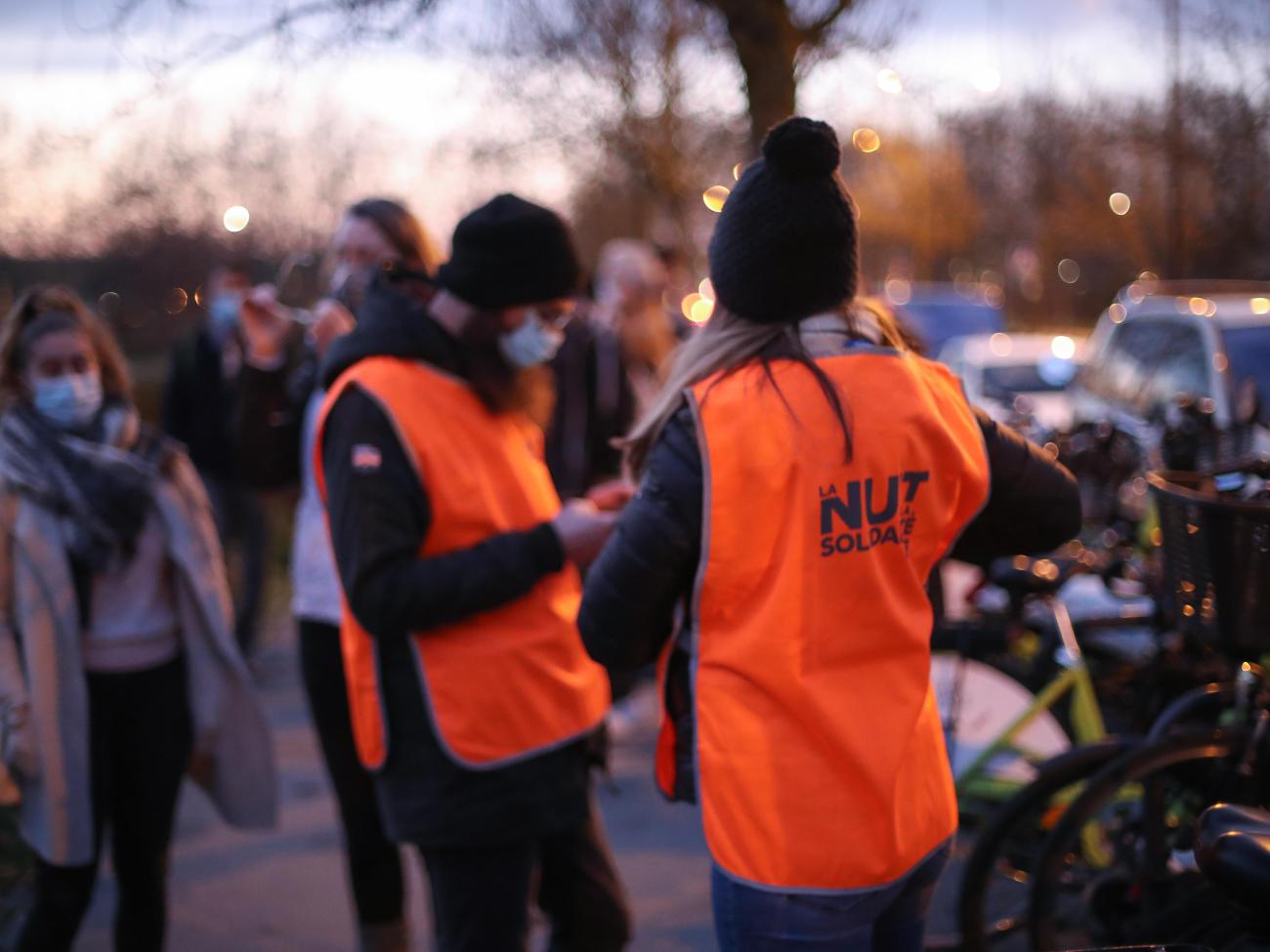 Photo de personnes avec des chasubles de la Nuit de la solidarité en début de soirée