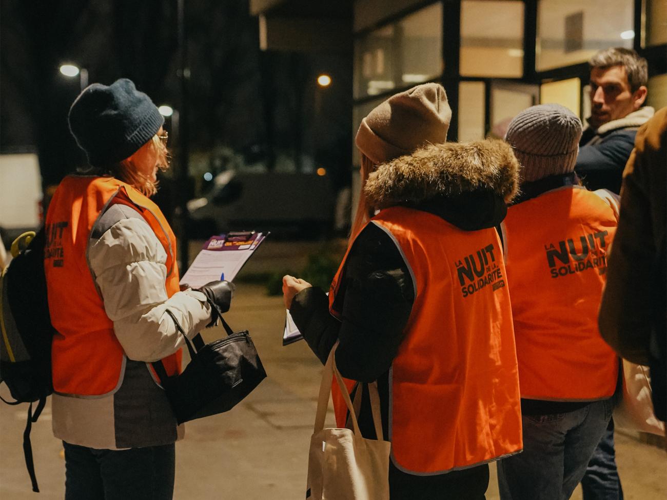Photo de bénévoles de la Nuit de la solidarité avec des questionnaires en main